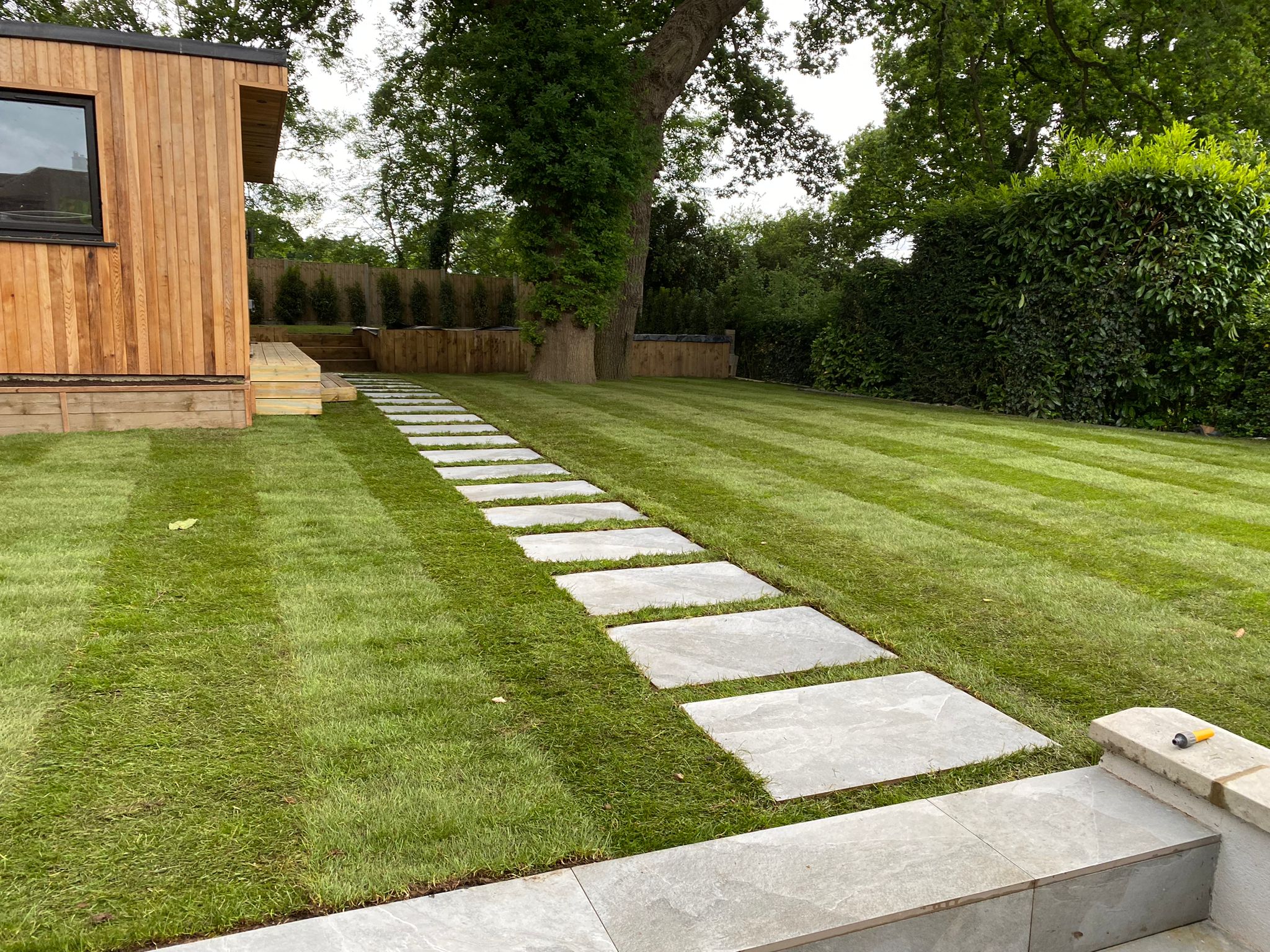 Freshly laid turf. Porcelain path. Garden office